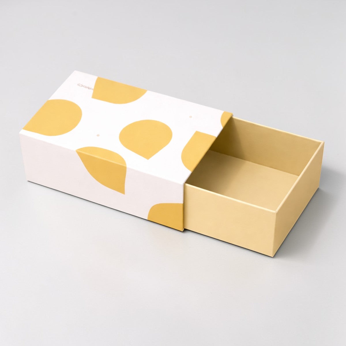 Stockka white and yellow polka dot drawer gift box, made of coated cardboard, perfect for jewelry or luxury items.