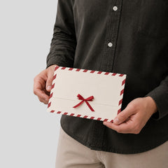 Stockka festive cream envelope with red ribbon and red stripe border, made of quality paper.