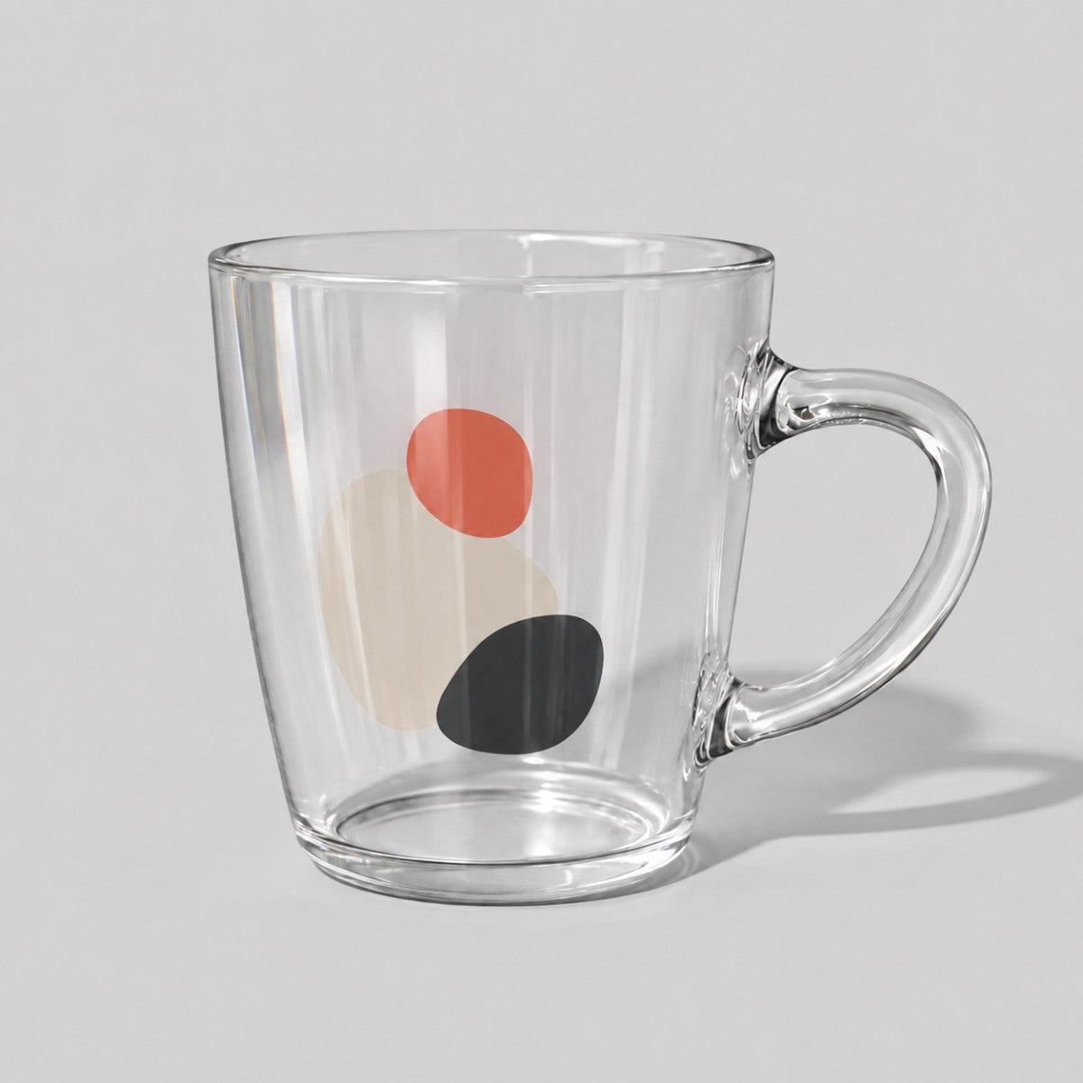 Stockka 475ml clear glass mug with a flared design and abstract red, beige, and black circular pattern.