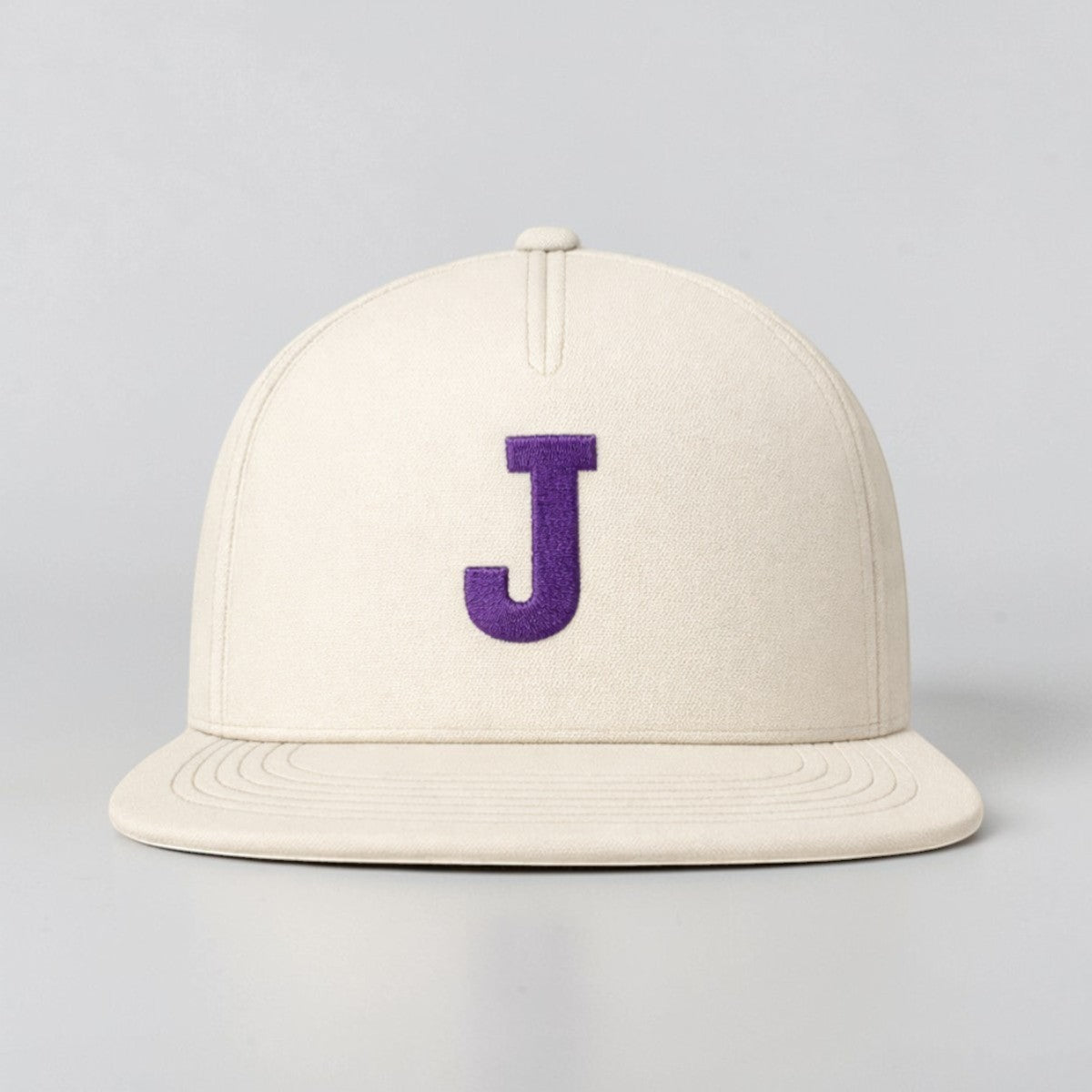 Stockkacap with a flat brim and a purple embroidered 'J' on the front, made of cotton.