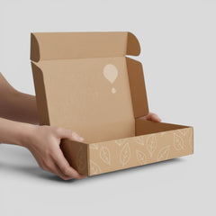 Stockka wide folding mailer box made of recycled cardboard with a leaf pattern and a logo.
