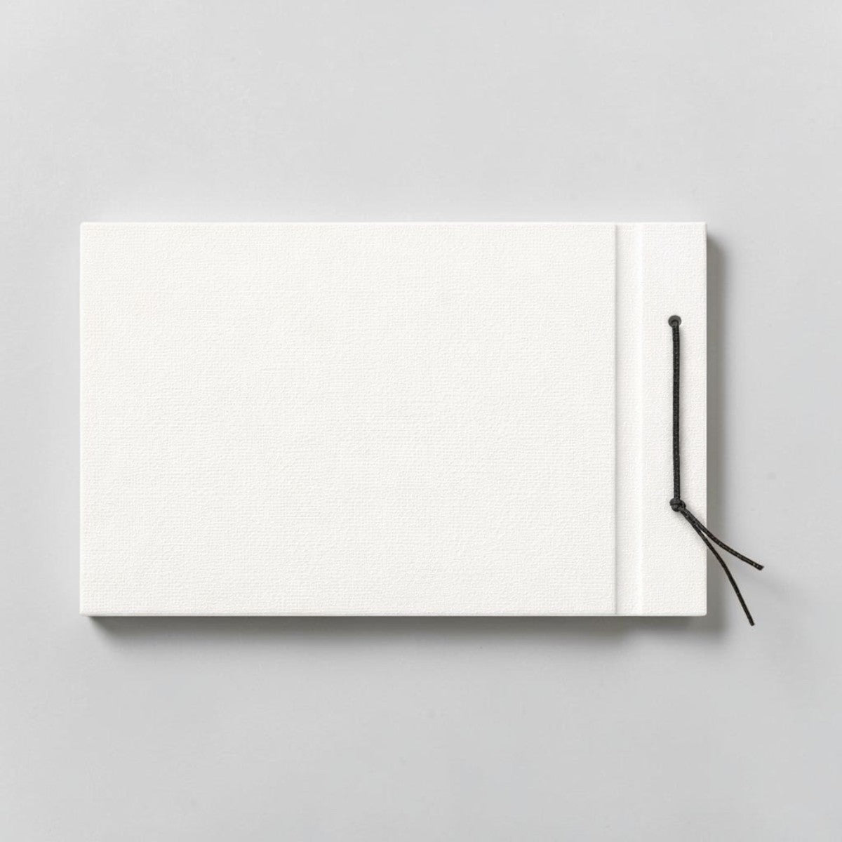 Stockka horizontal hard cover notebook with black string closure, 80 lined pages, customizable design.