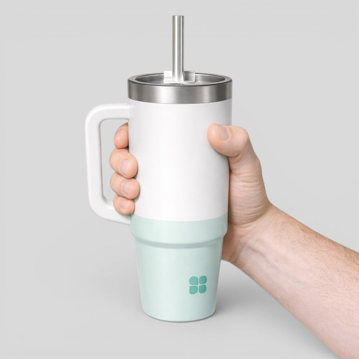 Stockka white and mint green insulated tumbler with handle and metal straw. Double-walled stainless steel construction.