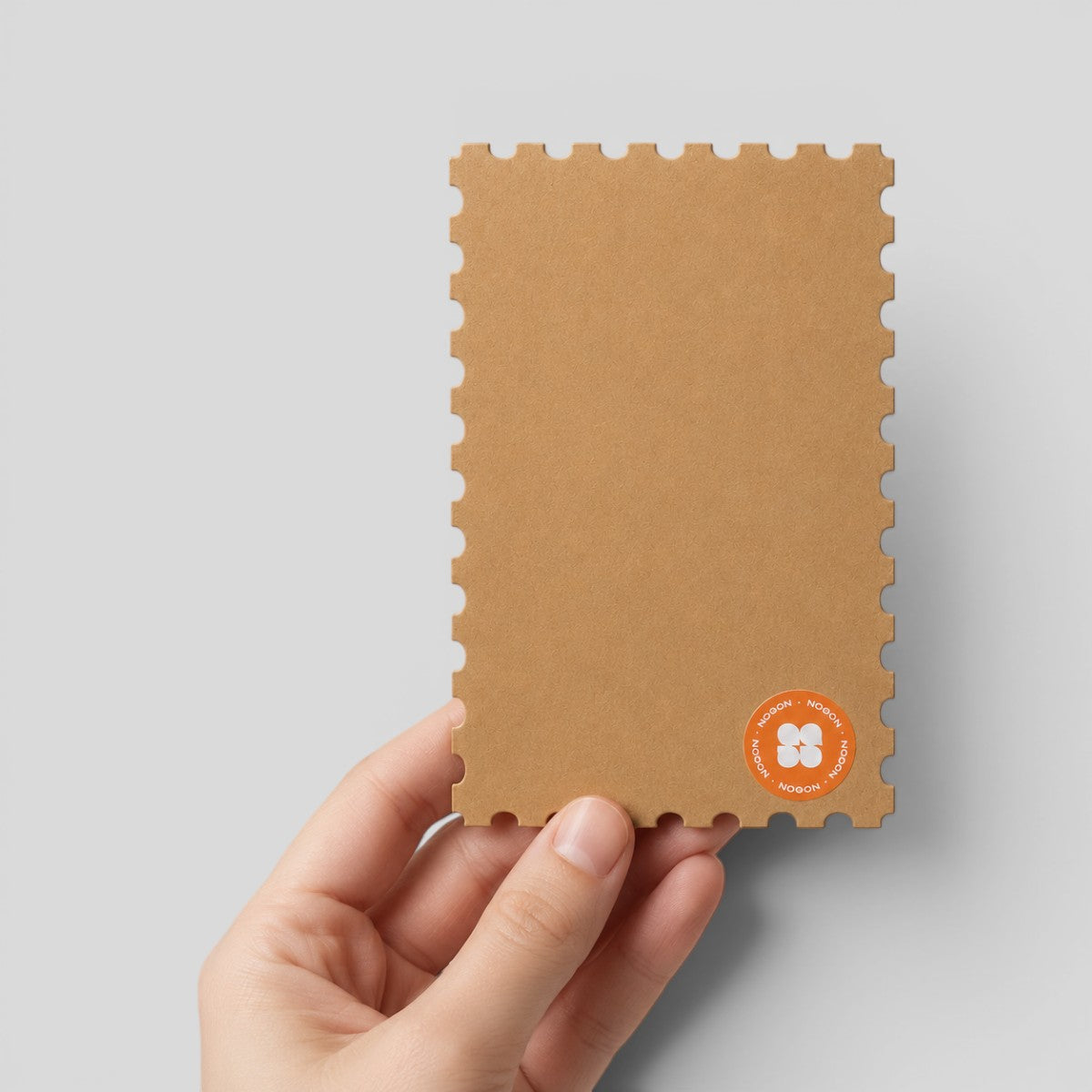 Stockka natural brown kraft paper greeting card with unique postage stamp style die-cut edges held in hand