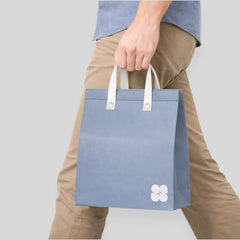 Stockka large blue non-woven polypropylene tote bag with white handles and a subtle floral logo, ideal for premium packaging or gifts.