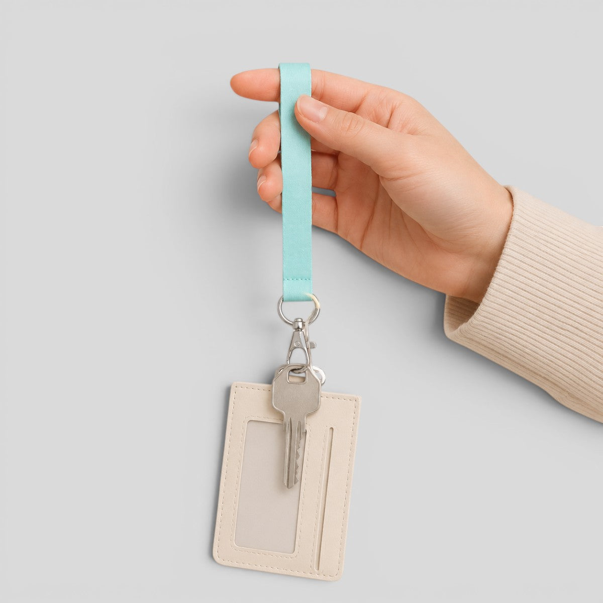 Stockka light blue polyester lanyard with flat metal clip holding a cream ID card holder and a silver key.