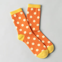 Stockka orange mid-calf socks with white polka dots and yellow cuffs and heels. Cotton and spandex blend.