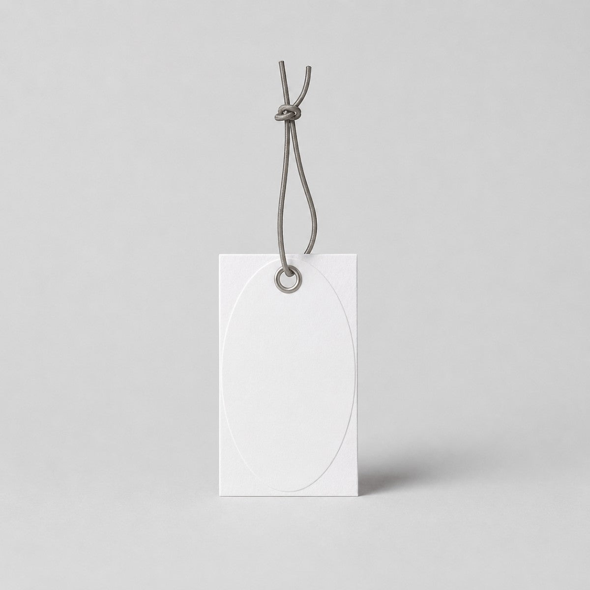 Stockka white oval embossed hang tag with reinforced eyelet and grey string