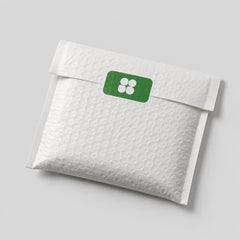 Stockka white padded envelope with rounded corner rectangular sticker featuring a green label with four white circles.