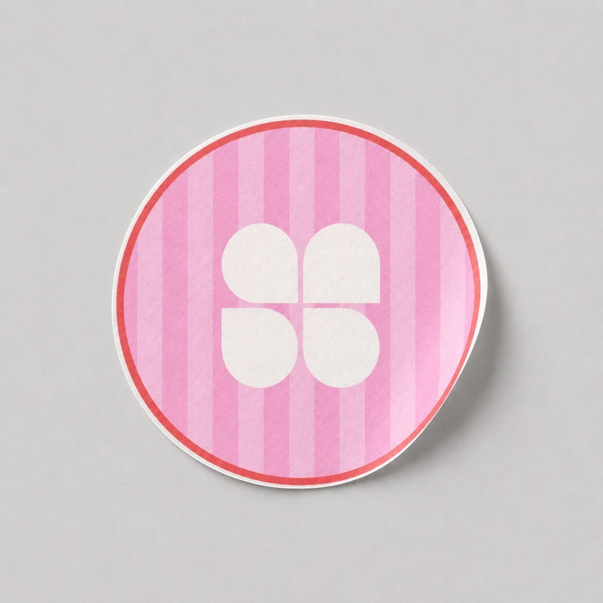 Stockka pink striped round sticker with a white four-petal flower logo and red border.