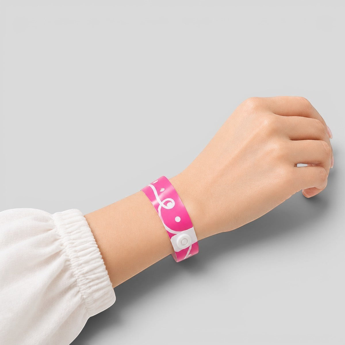 Stockka pink vinyl event wristband with white swirl pattern and secure snap closure. Water and tear resistant.