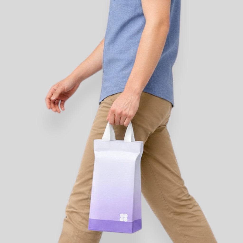 Stockka stand-up plastic gift bag with loop handles, white to purple gradient, and white floral logo.