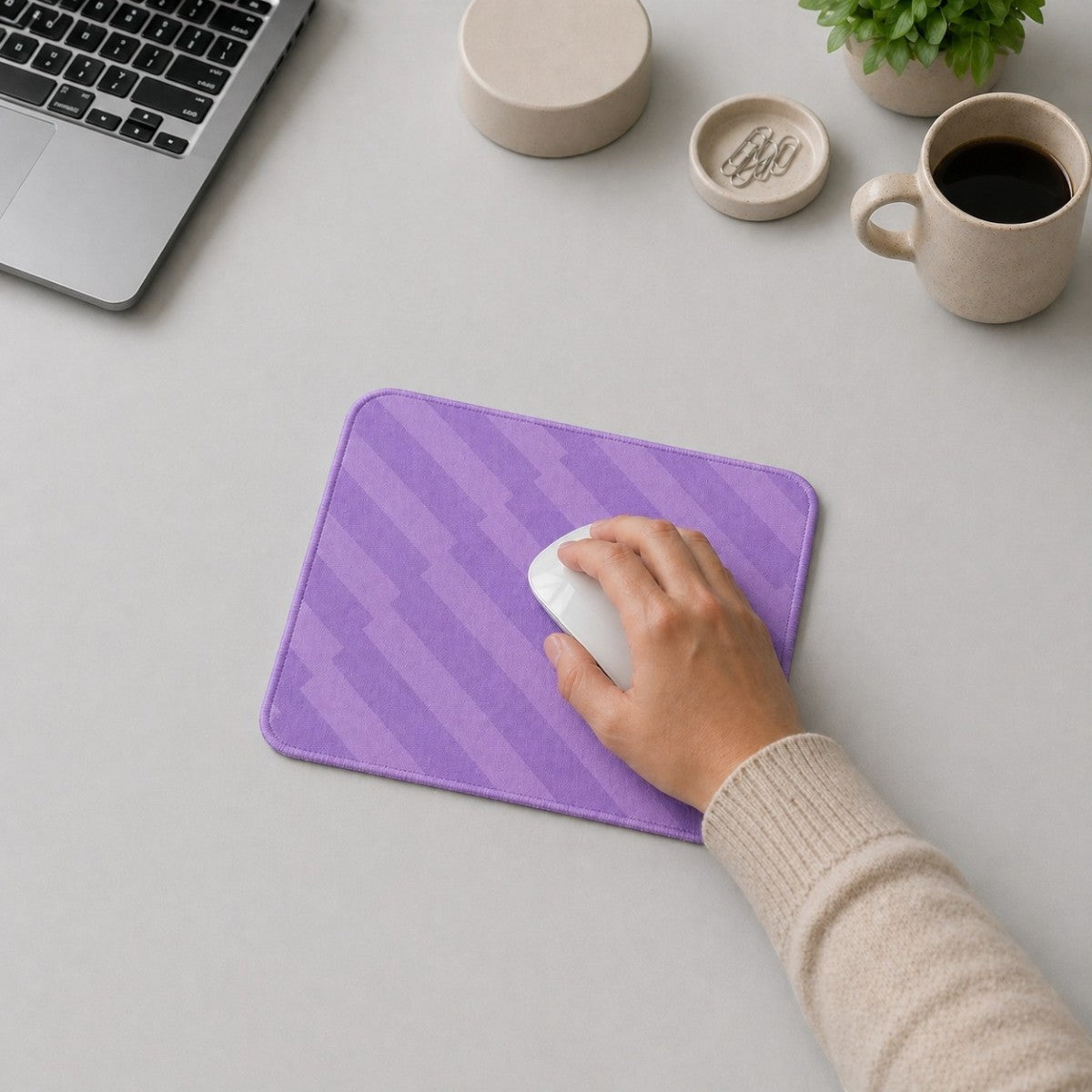 Stockka compact purple mousepad with rounded corners and a diagonal stripe pattern, used by a hand with a white mouse.