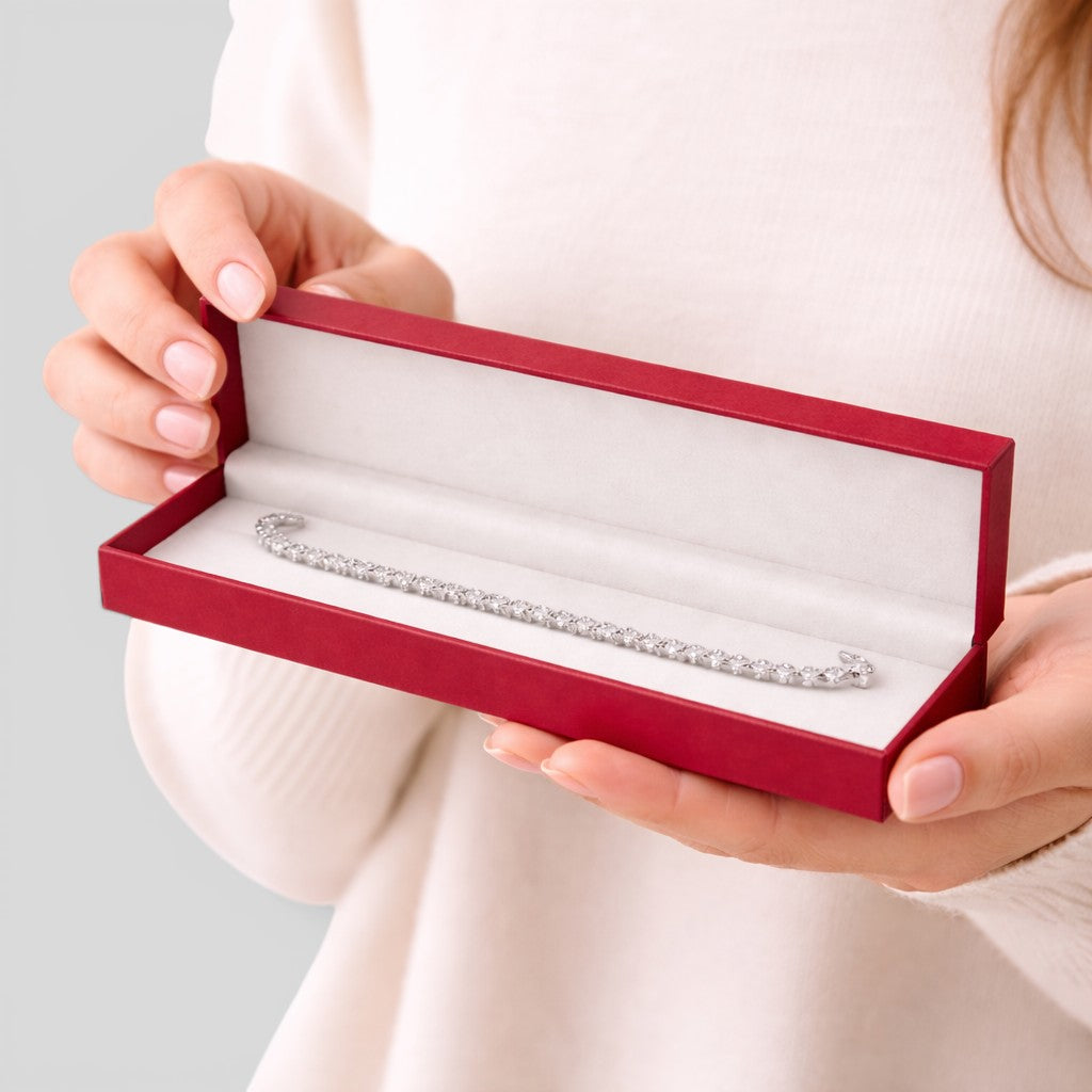 Stockka red jewelry box with white velvet lining holding a diamond tennis bracelet.