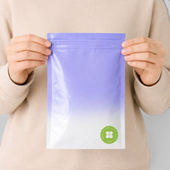 Stockka flat resealable plastic pouch with a purple to white gradient and a green circular logo. Perfect for food, cosmetics, and retail.