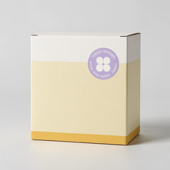 Stockka rigid cube gift box, white top, pale yellow body, and mustard yellow base. Features a purple circular logo with four white shapes.