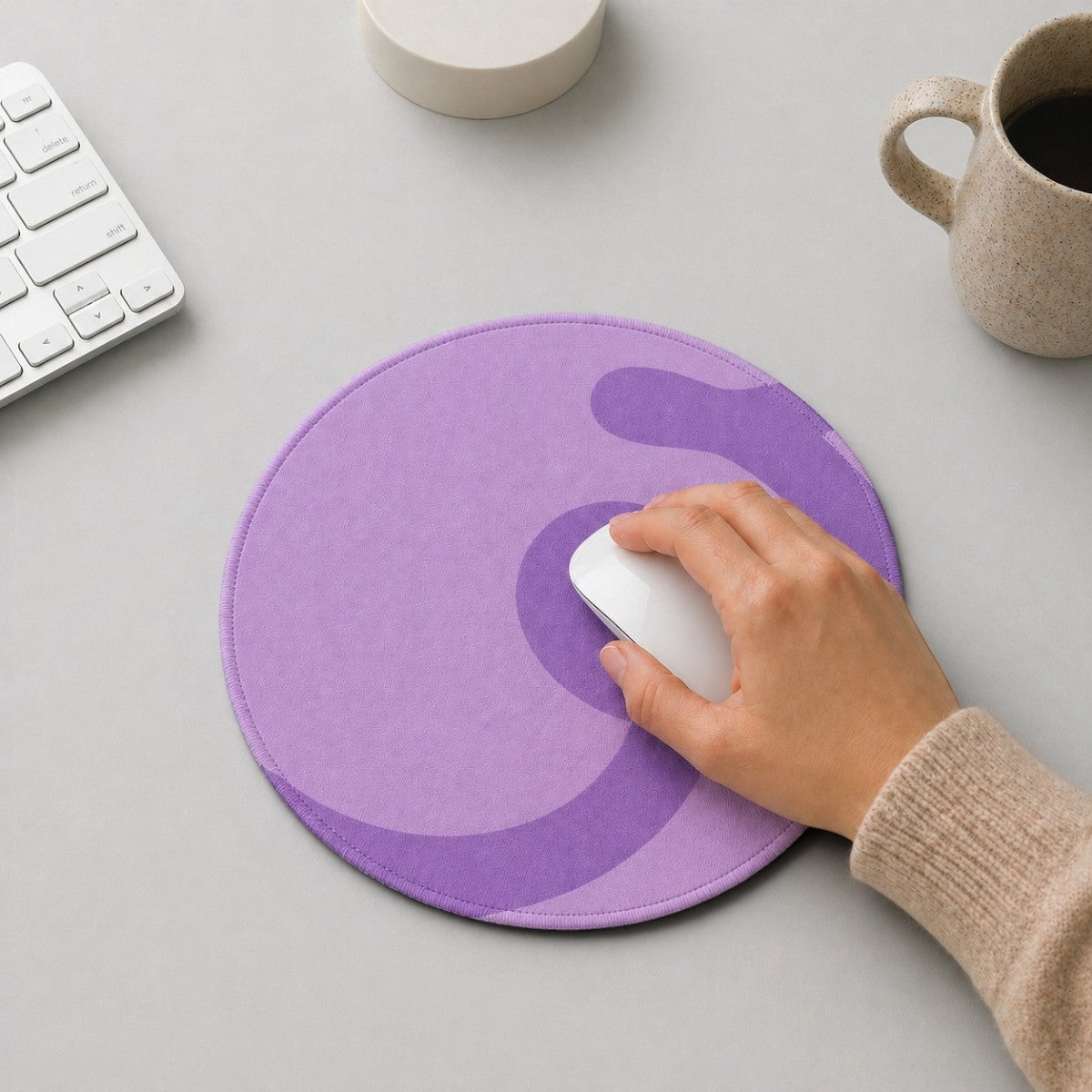 Stockka round mouse pad in light and dark purple abstract design, with a hand using a white mouse.