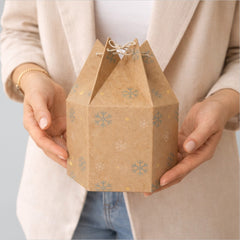 Stockka hexagonal kraft paper gift box with snowflake pattern and string closure, perfect for festive packaging.