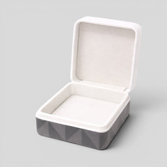 Stockka square jewelry box with hinged lid, grey exterior with geometric pattern, white interior lining, perfect for rings or necklaces.