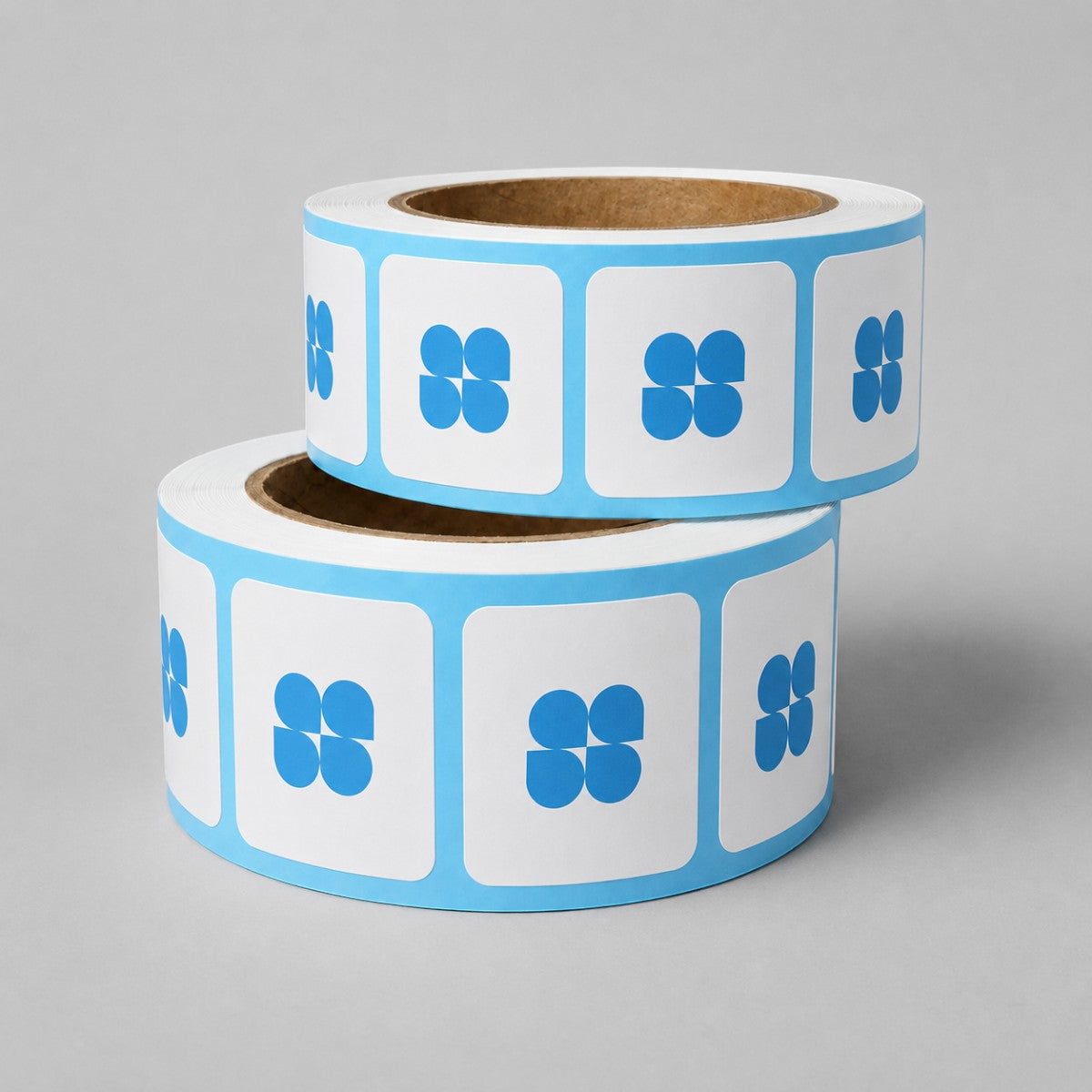 Stockka rolls of square stickers with rounded corners and blue cloverleaf logo. White stickers with blue border.