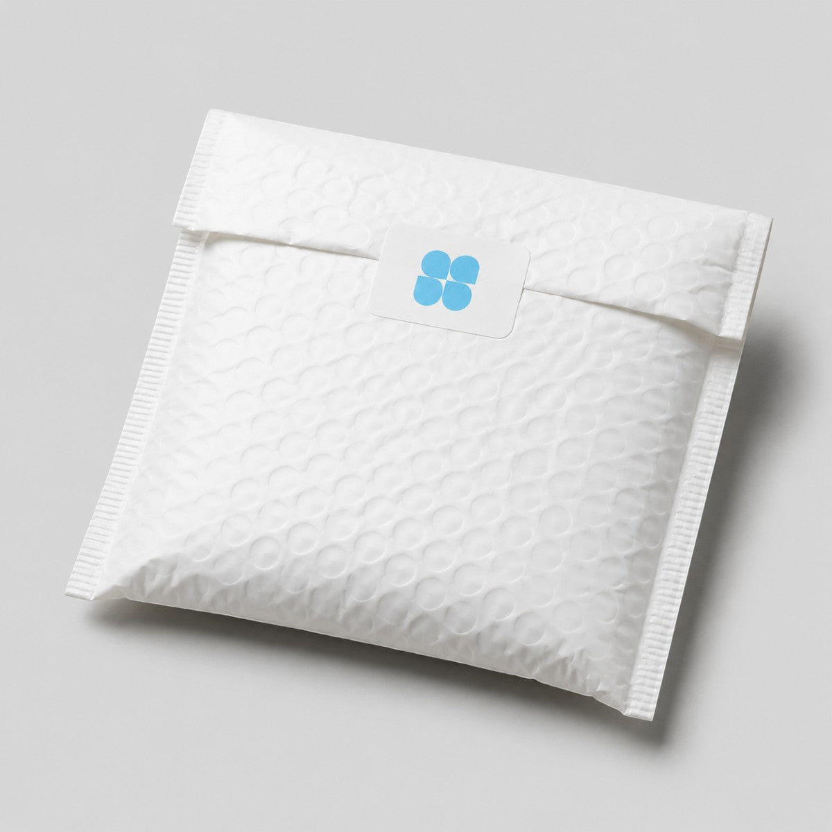 Stockka white square stickers with rounded corners and blue logo on a padded envelope.