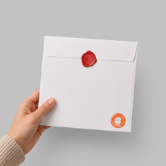 Stockka square white paper envelope with a red wax seal, held by a hand, perfect for formal invitations.