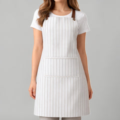 Stockka white and grey striped full-length apron with a large front pocket and leather shoulder straps. Made from cotton-polyester blend.