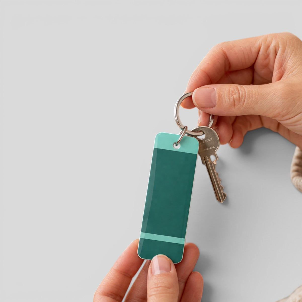 Stockka rectangular acrylic keychain with teal and light blue accents, featuring a metal ring and keys.