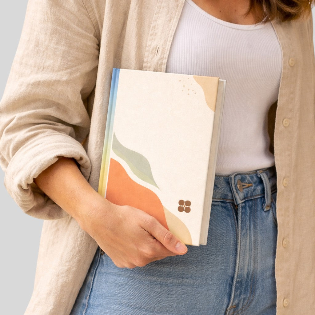 Stockka vertical hard cover notebook with abstract wavy design in cream, orange, green, and blue. 220 lined pages.