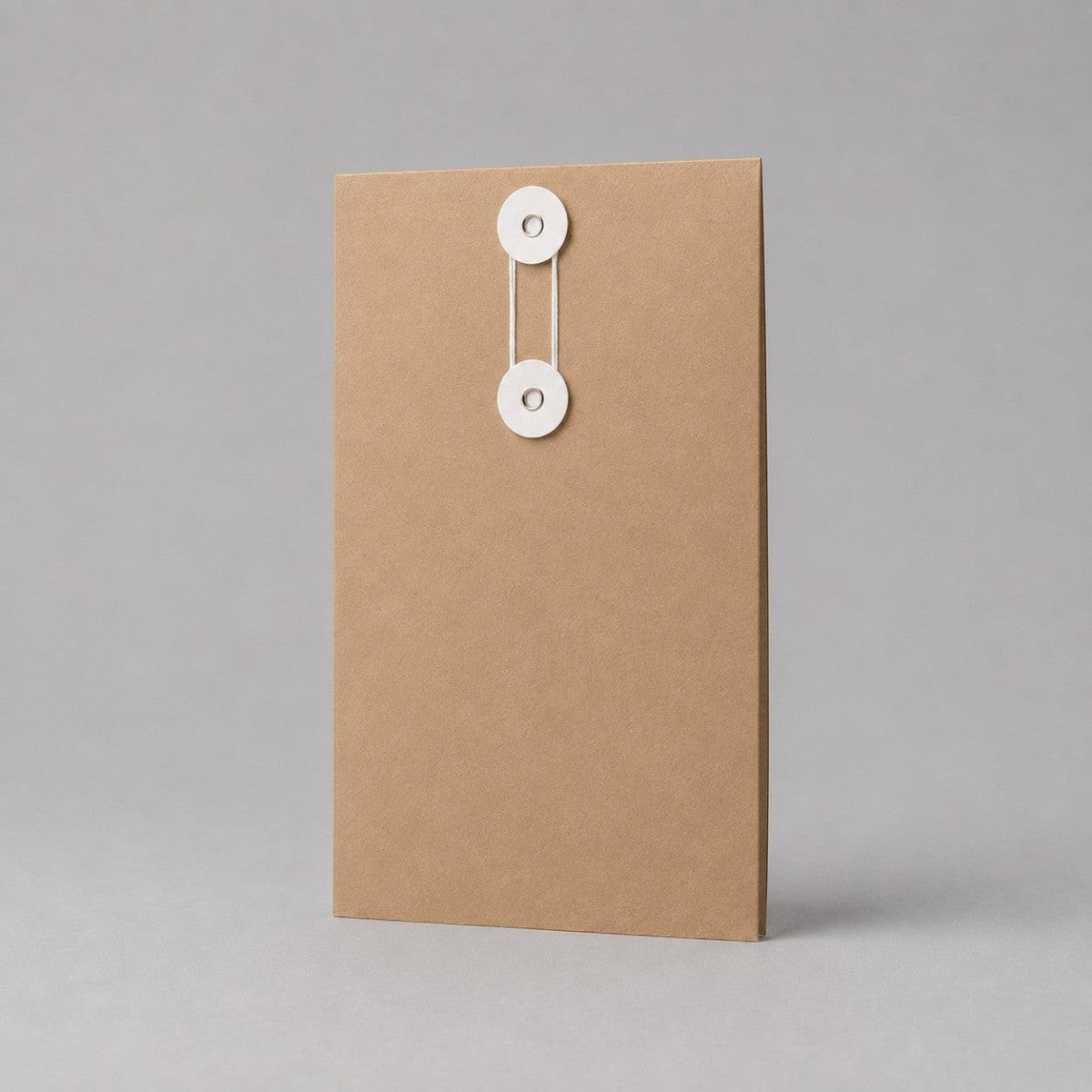 Stockka vertical brown kraft paper envelope with white string and disc closure, ideal for documents and contracts.