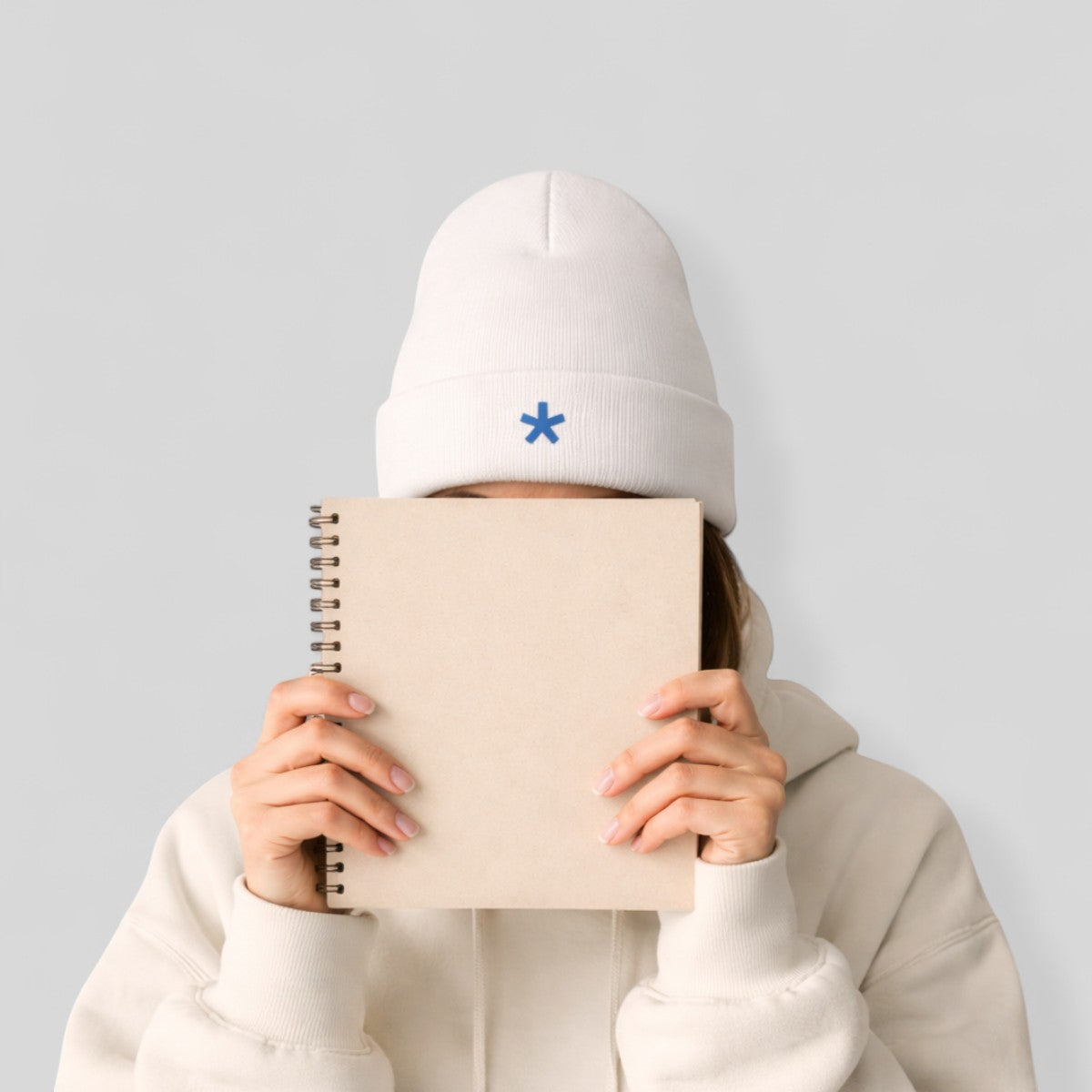 Stockka white acrylic knit beanie with blue asterisk logo and fold-up brim. Unisex winter hat.