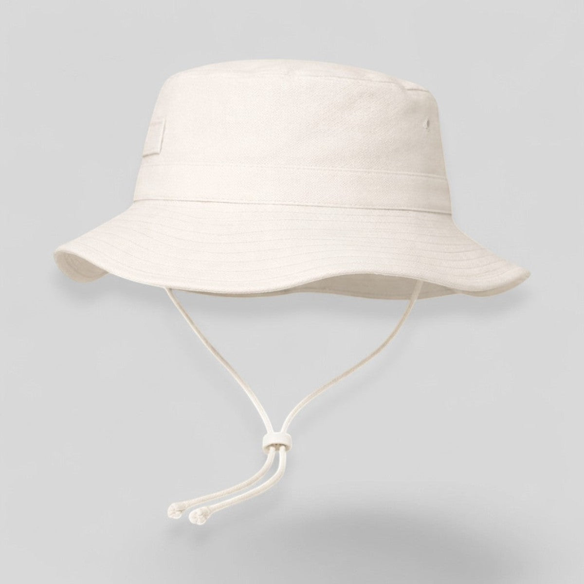 Stockka white cotton-polyester blend bucket hat with chin strap, ideal for surfing, beach, golf, and fishing.