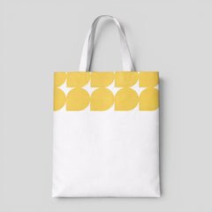 Stockka white canvas tote bag with a yellow abstract leaf pattern at the top. Made of 100% cotton.