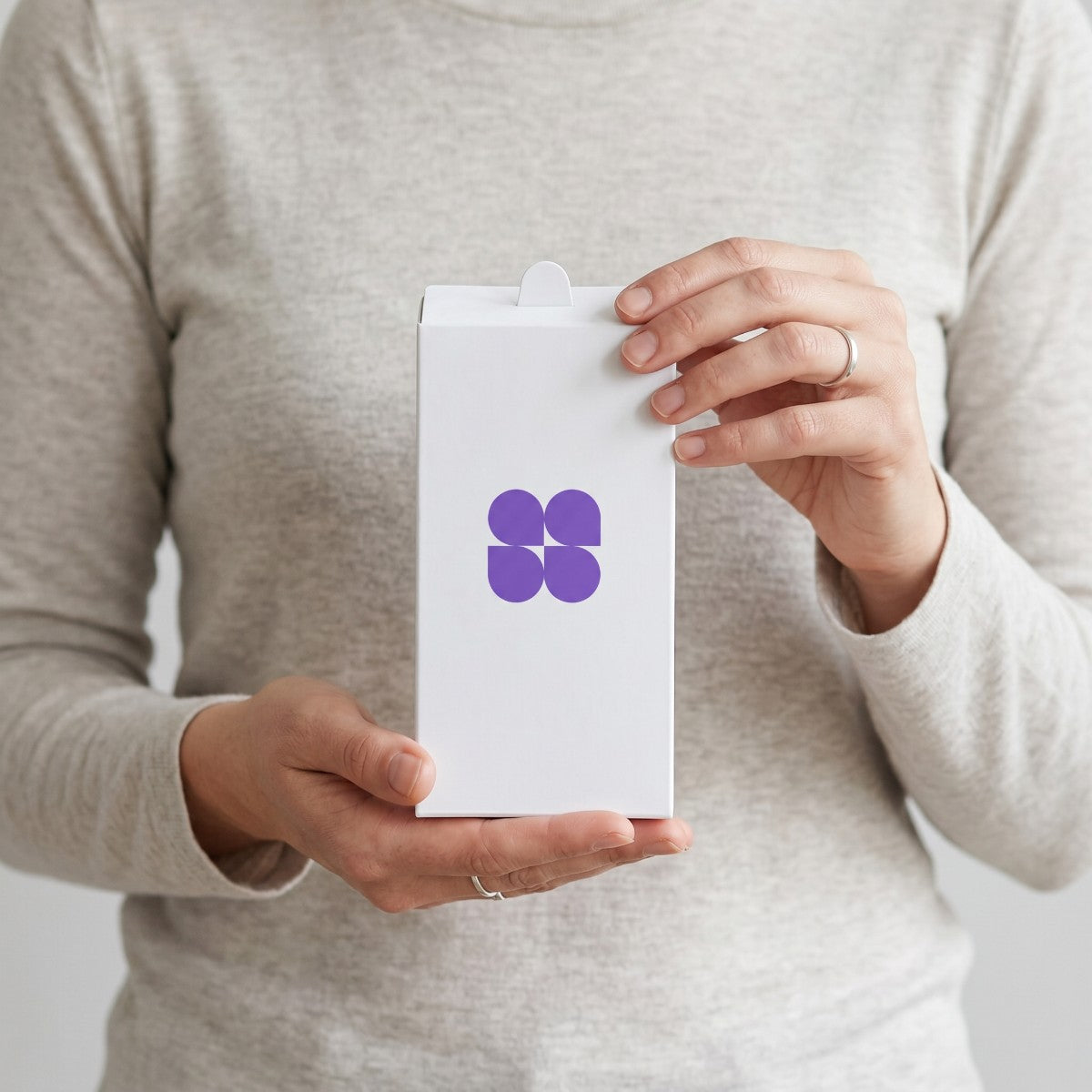 Stockka white matte cardboard box with top tab closure held by a person, ideal for branded packaging.