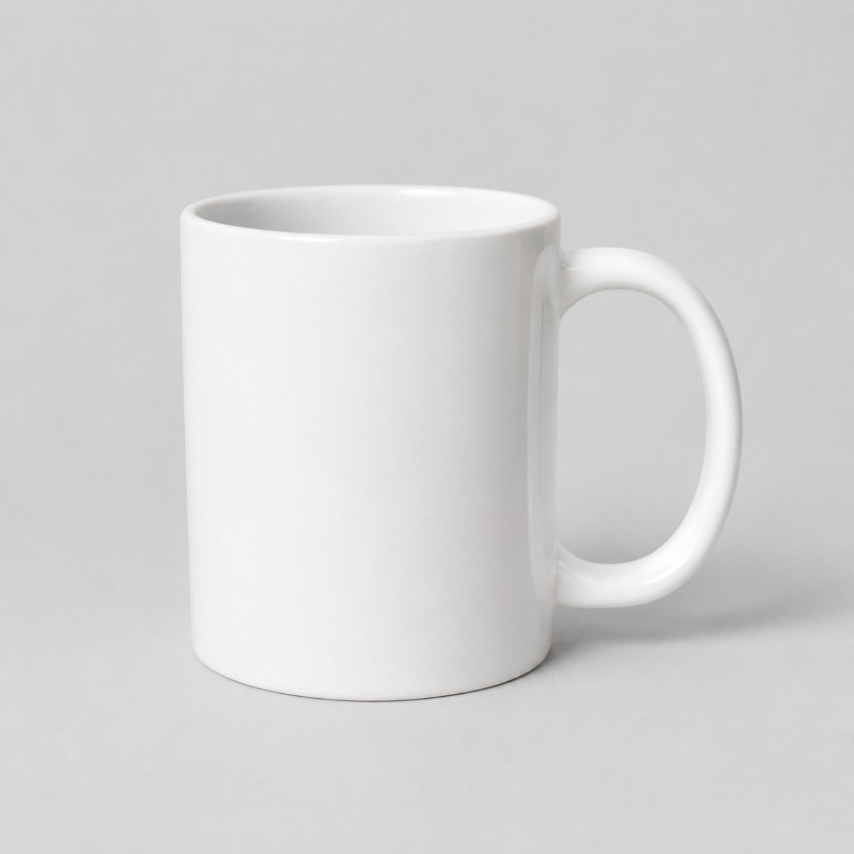 Stockka classic white ceramic mug with a comfortable handle for coffee or tea, isolated on a light grey background.