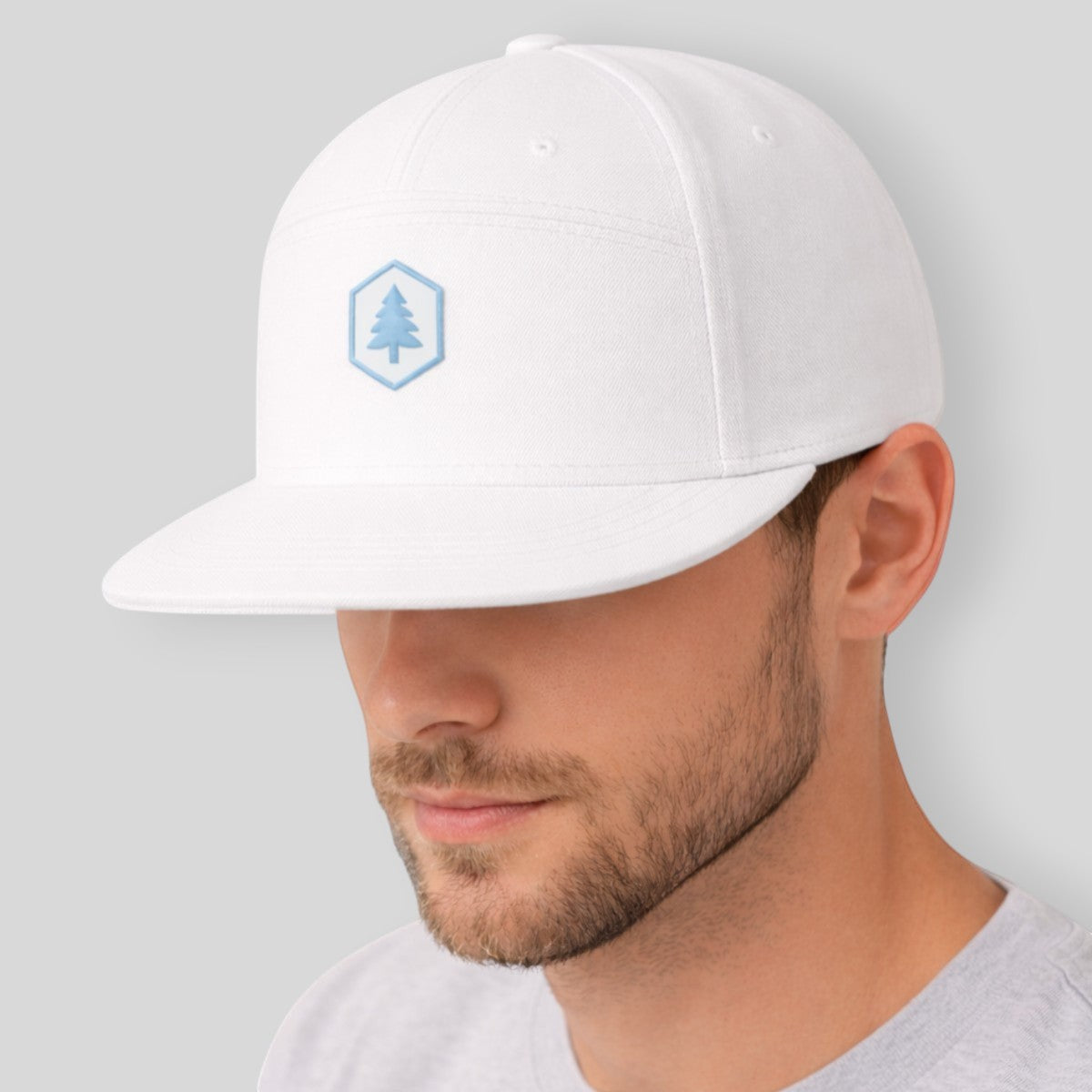 Stockka white 100% cotton unisex baseball cap with a light blue tree logo emblem. Adjustable fit.