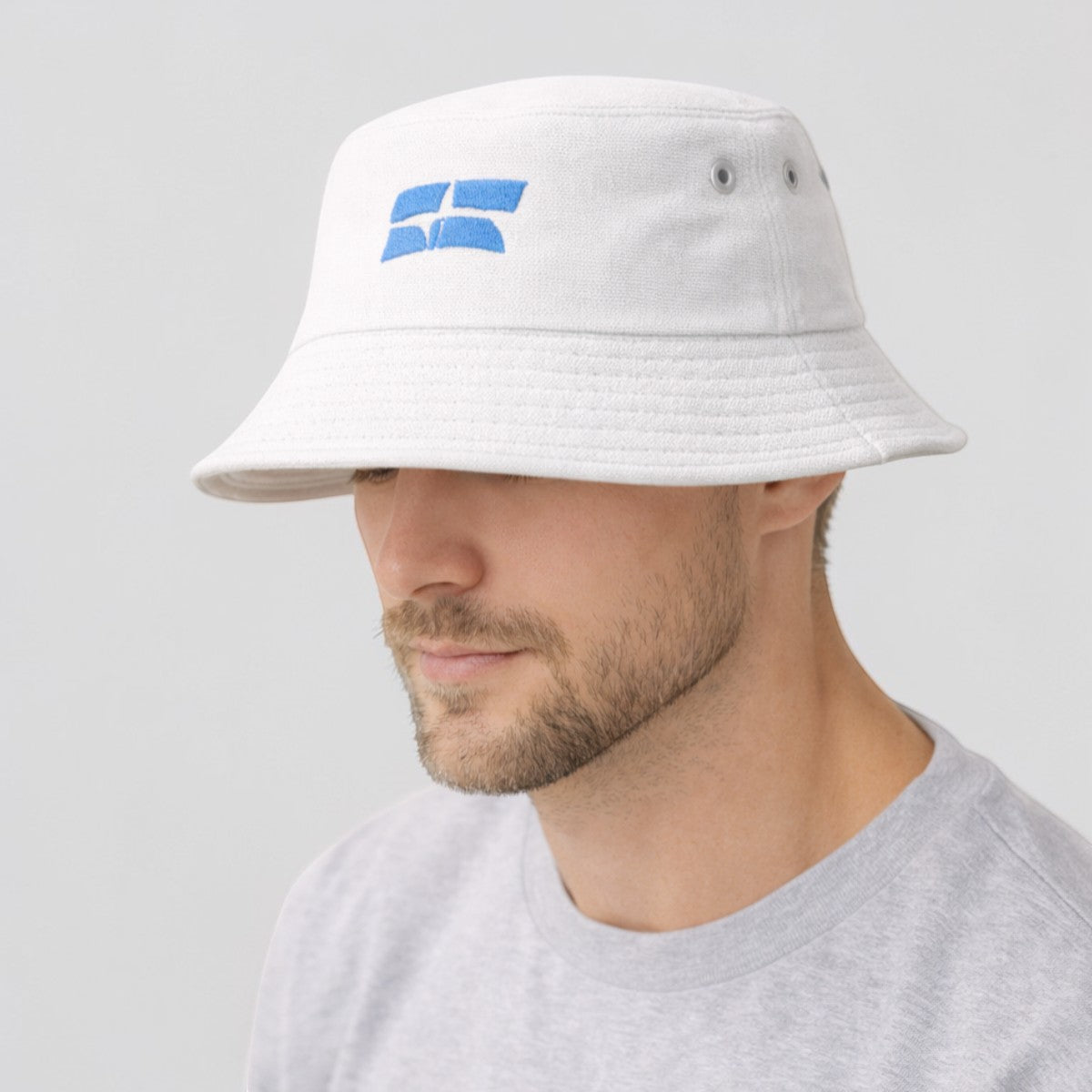 Stockka white cotton bucket hat with blue embroidered logo. Unisex, adjustable fit, lightweight and durable.