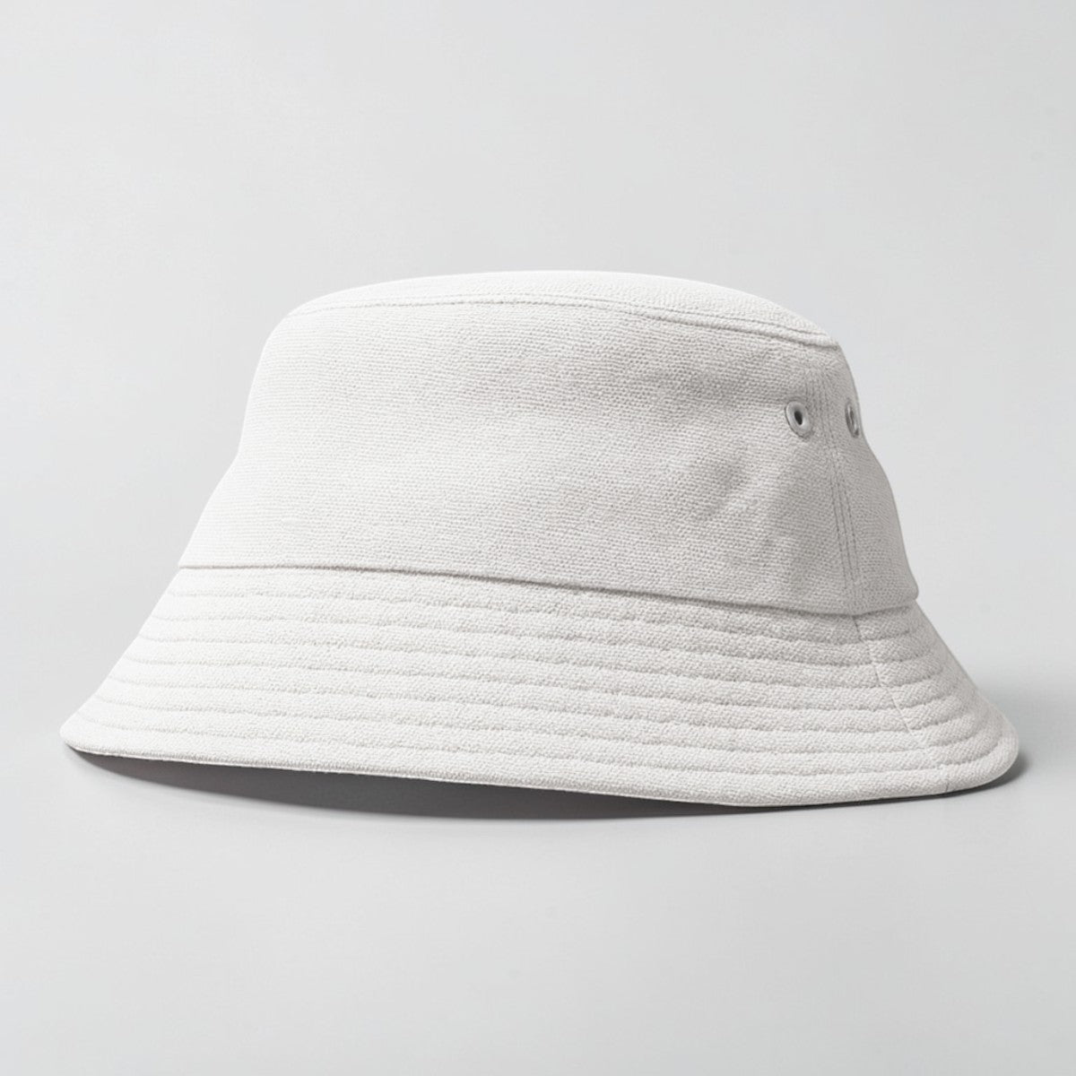 Stockka white cotton bucket hat with eyelets and a textured brim. Unisex design.