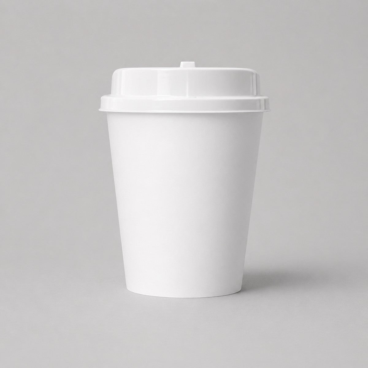 Stockka white double-walled paper coffee cup with kraft sleeve and white lid, ideal for hot beverages.