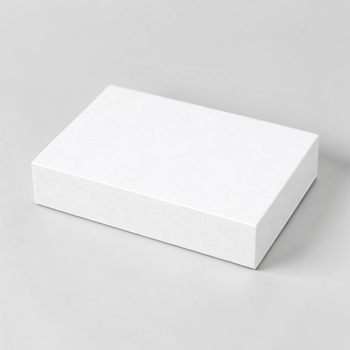 Stockka minimalist white flat cardboard gift box for shirts and apparel. High-quality rigid cardstock packaging.