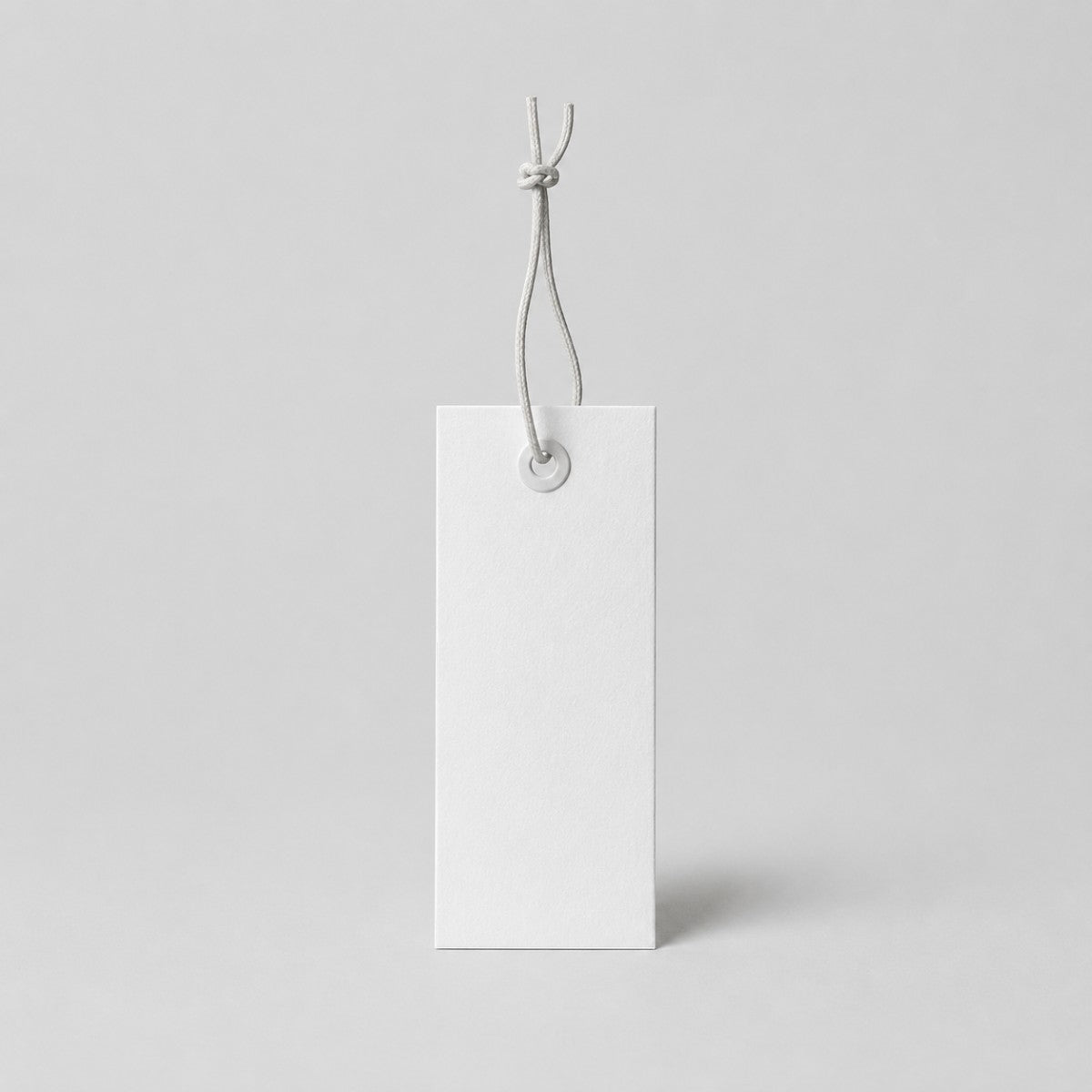 Stockka white rectangular hang tag with reinforced eyelet and string, ideal for retail.