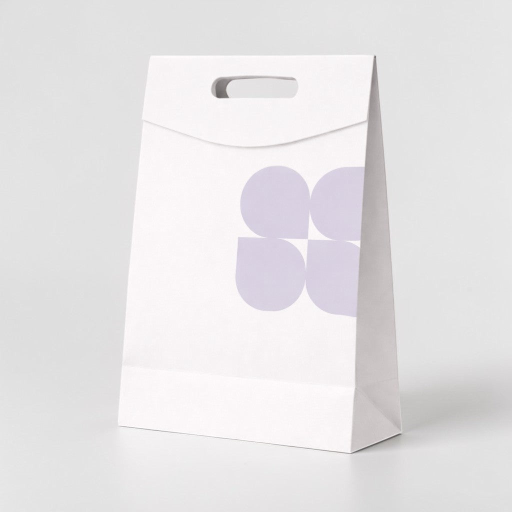 Stockka white kraft paper shopping bag with die-cut handle and subtle purple floral pattern. Ideal for retail packaging.