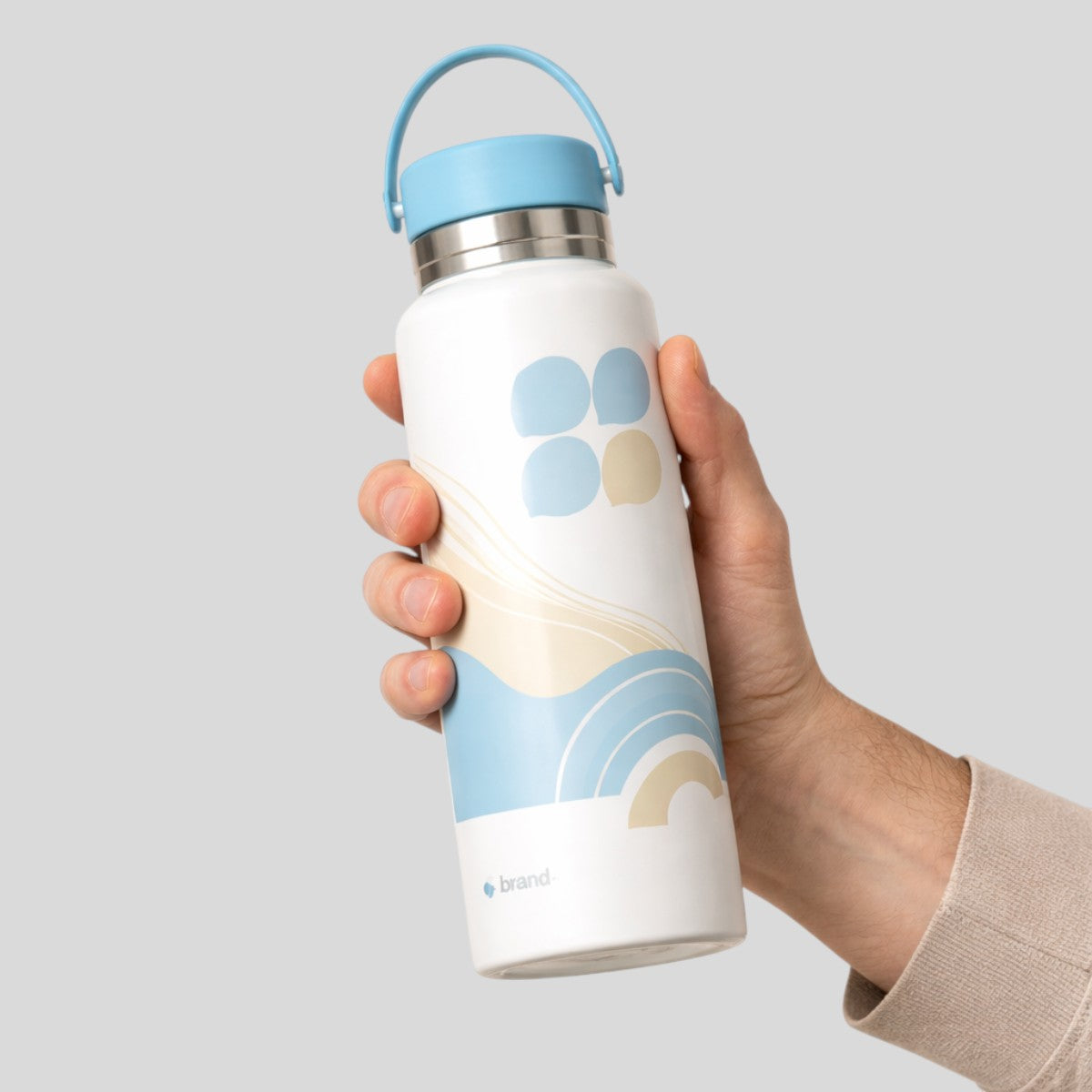Stockka white metal water bottle with blue lid and silicone handle, featuring a blue and beige abstract wave design.