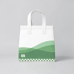 Stockka medium white non-woven polypropylene tote bag with green wavy design and clover detail.