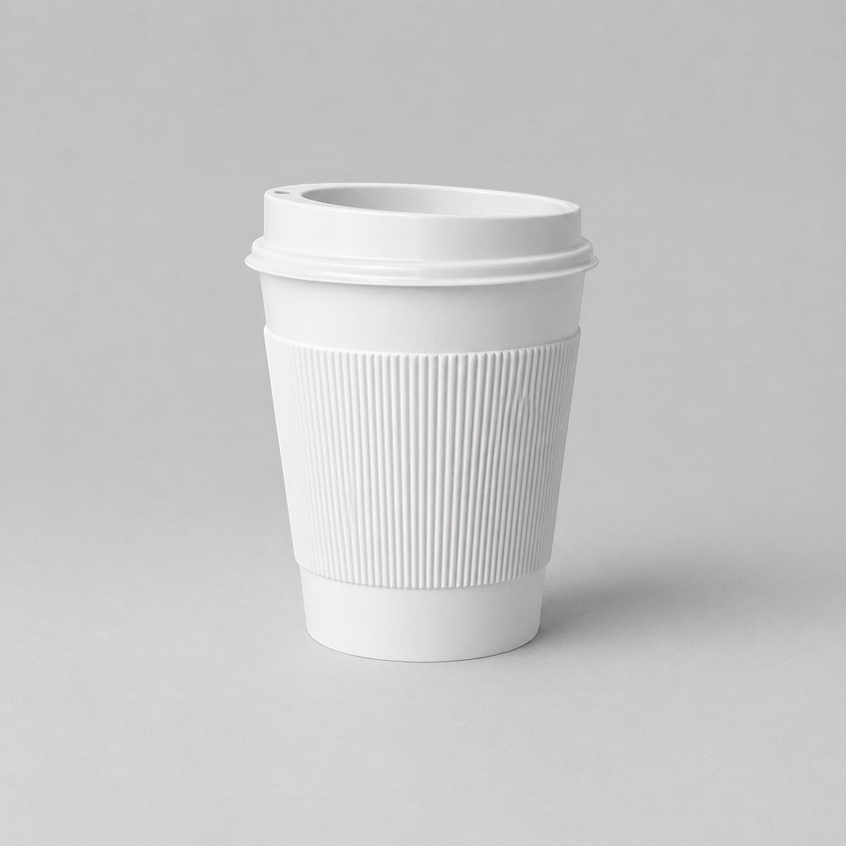 Stockka white paper coffee cup with ribbed kraft sleeve and black plastic lid, 350ml capacity.
