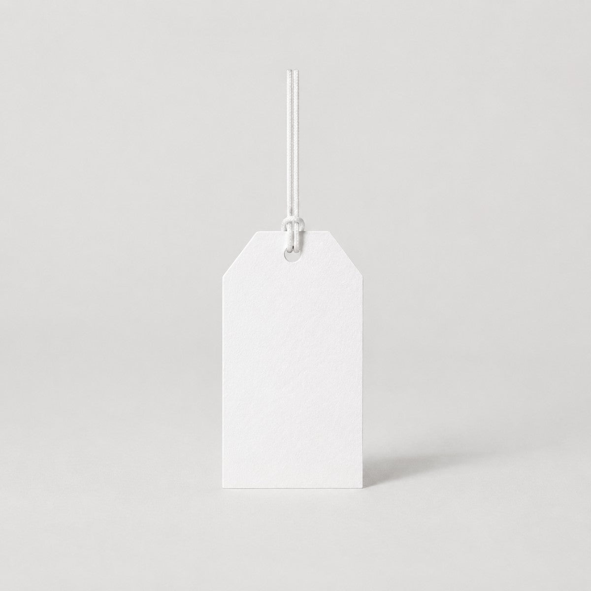 Stockka classic white paper hang tag with reinforced hole and string, ideal for clothing and retail.