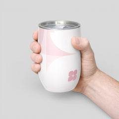 Stockka white insulated wine tumbler with pink abstract design and clear lid, held by a hand.