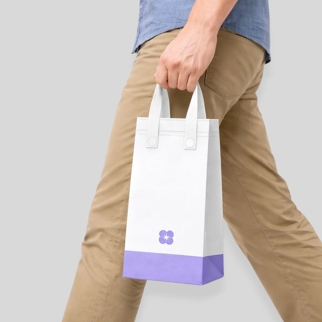 Stockka white non-woven tote bag with purple base and floral logo, ideal for carrying cups.