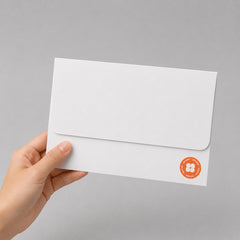 Stockka white envelope with a rounded front flap, made of 250gsm wood-free paper, held in a hand.