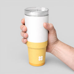 Stockka white and yellow double-walled stainless steel thermal tumbler with clear lid, held by hand.